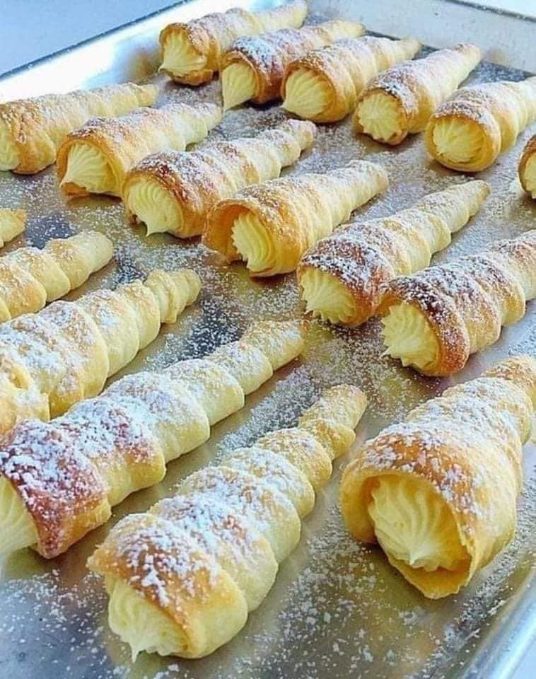 Cannoncini rellenos de crema italiana: cannoncini (cuernos) de hojaldre crujiente y mantecoso rellenos de una rica y aterciopelada crema pastelera